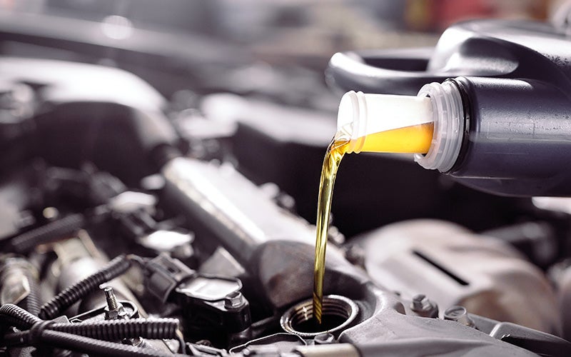 Technician performing a synthetic oil change on a Jeep at Cable Dahmer CDJR of Kansas City