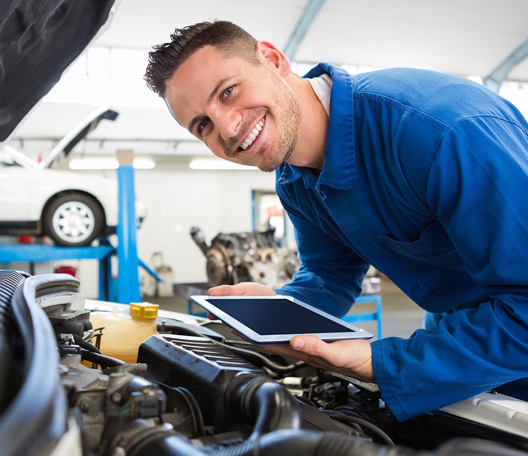 Certified technician performing a multi-point inspection on a used vehicle at Cable Dahmer CDJR of Kansas City