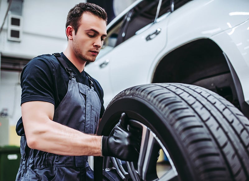 Certified technician performing a wheel alignment at Cable Dahmer CDJR of Kansas City